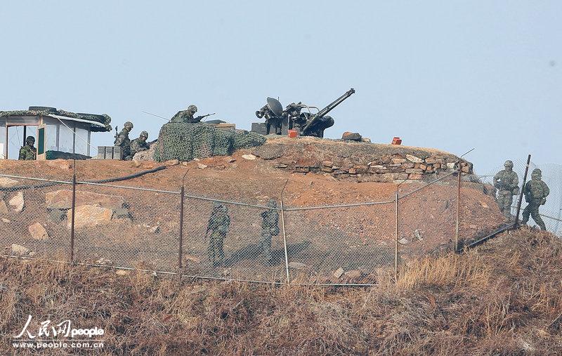 2013年3月13日,韩国延坪岛,韩国海军陆战队员正在一处高炮阵地演练.