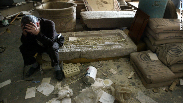 2003年4月13日，伊拉克国家博物馆的文物因战争大面积损坏，图为博物馆馆长哈桑怅然地坐在博物馆的废墟之上。（图片来自CNN网站）