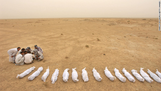 2003年5月31日，伊拉克人对照死亡名单，在穆赛伊卜附近的乱葬岗中寻找着死者的遗骸。（图片来自CNN网站）