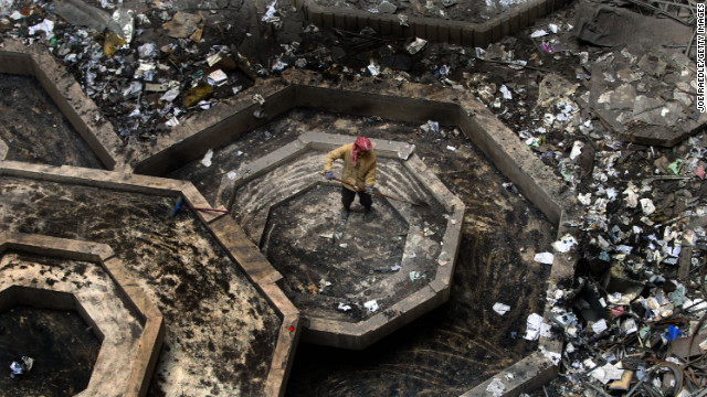 2003年12月11日，一名建筑工人在清扫被炸弹摧毁的残骸遗迹。（图片来自CNN网站）