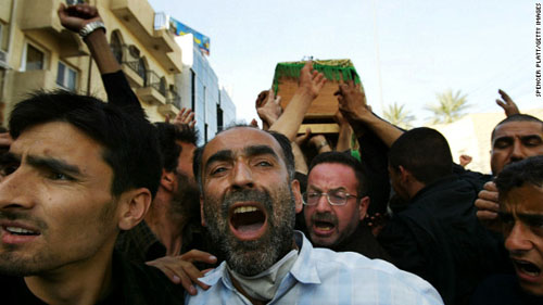 2004年3月3日，卡尔巴拉街头的悼念者举着木棺哀悼亡魂。一天后，在什叶派穆斯林的阿舒拉节仪式之上，一场大型的轰炸又造成了数十人死亡，数百人受伤。（图片来自CNN网站）