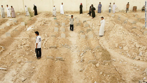 2004年5月3日，伊拉克民众满眼伤痛地凝望着遍地的坟冢，这密集的坟墓被设在了费杰卢的足球赛场上。（图片来自CNN网站）