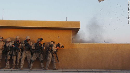 2004年11月22日，美国海军陆战队员使用炸弹来打开天台门以便进入房间搜查费卢杰的反动武装份子。（图片来自CNN网站）