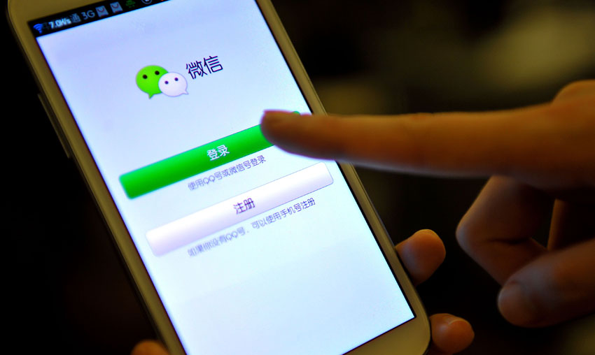 2013年4月7日，一名参加论坛的记者在使用微信软件。摄影：新华社记者  郭程