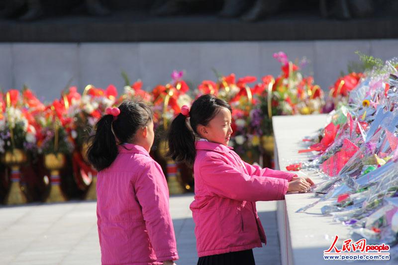 一对朝鲜双胞胎姐妹前往万寿台金日成、金正日铜像献花。