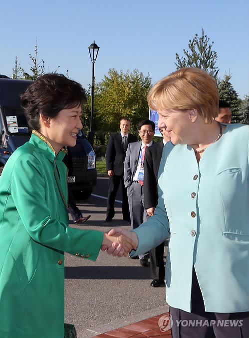 6日,韩国总统朴槿惠在圣彼得堡会见德国总理默克尔,双方亲切握手。(韩联社)