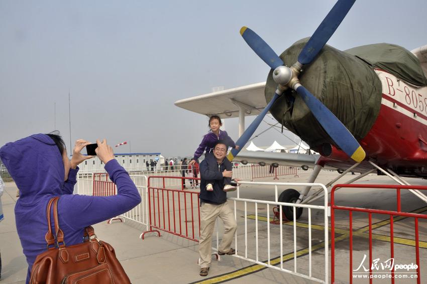 航空展飞行节进入第三日,一对父女在北京八达岭机场运-5b飞机前留影