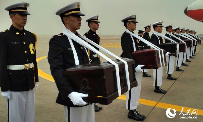 韓方軍人手捧烈士遺骸棺木。