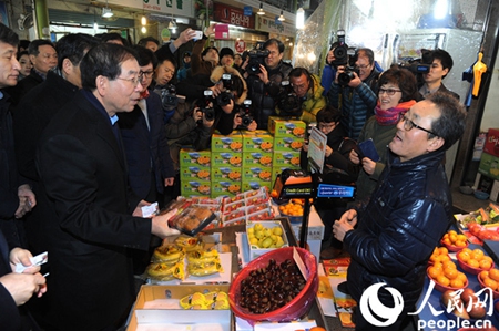 首尔市长朴元淳在传统市场购买商品，体验公交卡结算方式。（图片来源：首尔市）