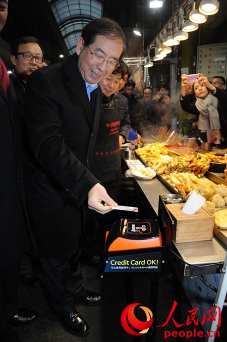 首尔市长朴元淳在传统市场体验公交卡结算方式。（图片来源：首尔市）