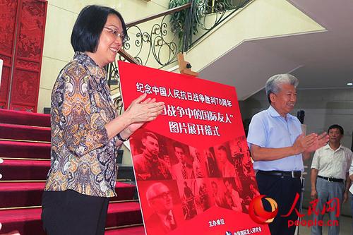 北京市友协常务副会长田雁和中国国际友人研究会会长马灿荣共同为图片展揭幕。（人民网 孔德芳 摄）