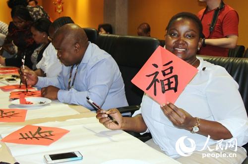 一名南非官员兴奋地展示自己的中国书法作品。 人民网记者 李志伟摄
