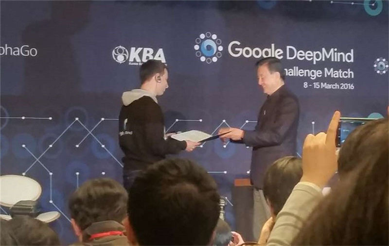 韩国棋院总裁洪锡炫为阿尔法棋研发团队的大卫·西尔沃颁发荣誉九段证书