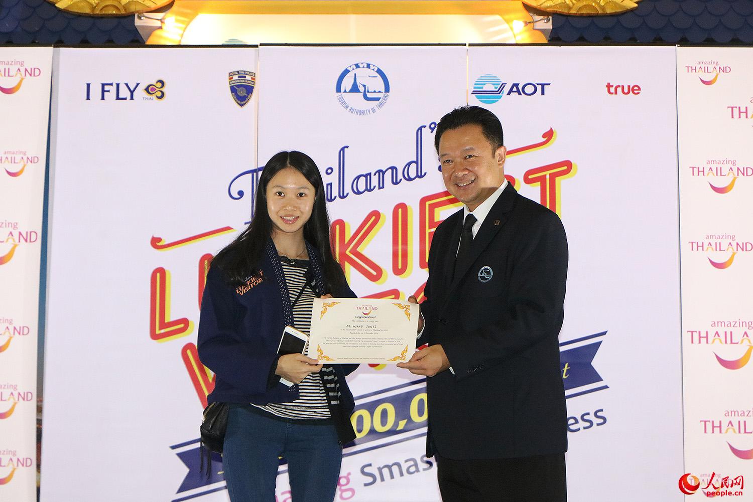 泰国国家旅游局局长育他萨向第3000万名游客颁发“泰国最幸运游客”证书。
