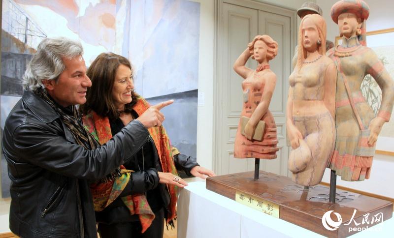 欧盟机构两名工作人员驻足欣赏展出的一件木雕作品。记者任彦摄