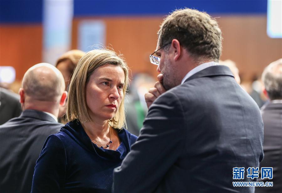 12月8日,在德国北部城市汉堡,欧盟外交与安全政策高级代表莫盖里尼(左)准备出席第23届欧洲安全与合作组织(欧安组织)外长会议。