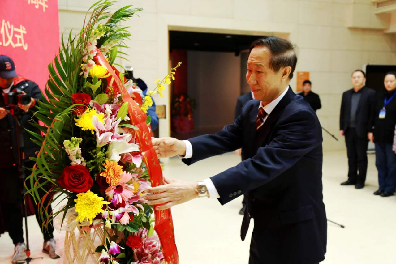 全国政协副主席、中国宋庆龄基金会主席王家瑞在整理花篮缎带。