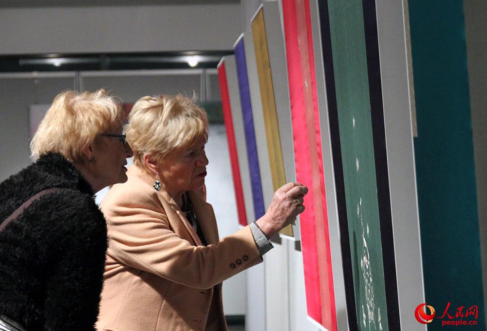 两名德国观众在欣赏梁永钢作品。人民网记者管克江摄