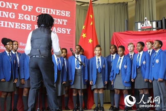 3月6日，中国驻南非大使馆向南非豪登省10所中小学捐赠汉语教材和课外读物。南非学生在捐赠仪式上合唱改编自《北京欢迎你》的《南非欢迎你》。人民网 张洁娴 摄