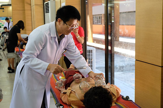 3月26日，“中医养生保健泰国行”第二站义诊活动在泰国罗勇府举行。泰国中医师在义诊活动现场为患者进行拔罐治疗。泰国东方大学孔子学院供图