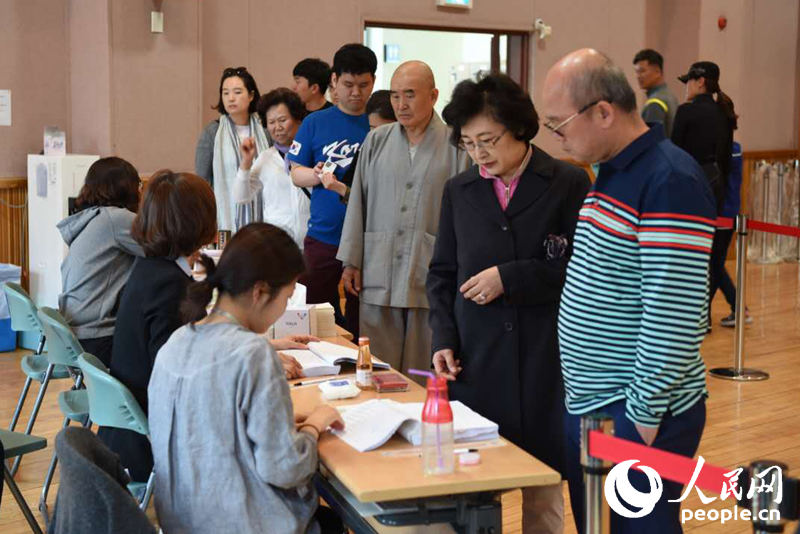 韩国民众排队领取选票。裴��基摄