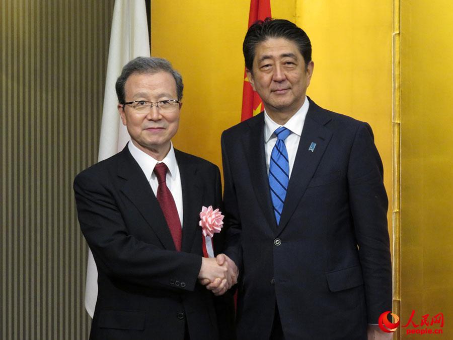 中国驻日本大使程永华与安倍首相在会场入口处合影。 滕雪摄