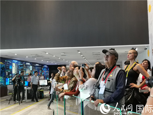中外记者在观看天津生态城智慧运营中心的大屏幕。