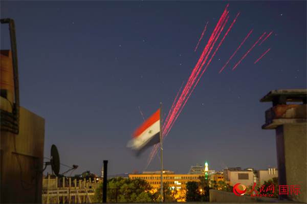选举结果公布后，叙利亚首都大马士革民众向天空开枪庆祝，图为划破夜空的子弹。薛丹 摄