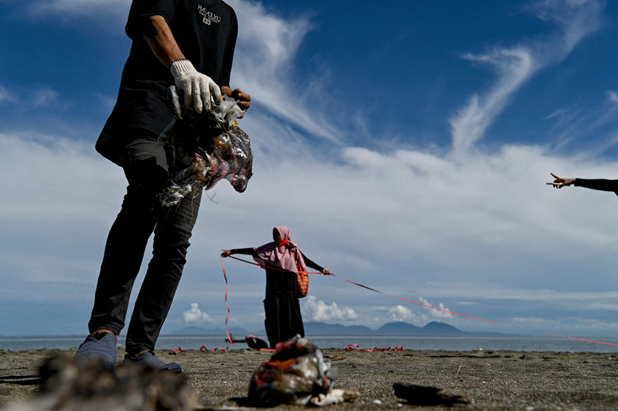 印度尼西亚志愿者在海滩捡拾垃圾保护生态环境