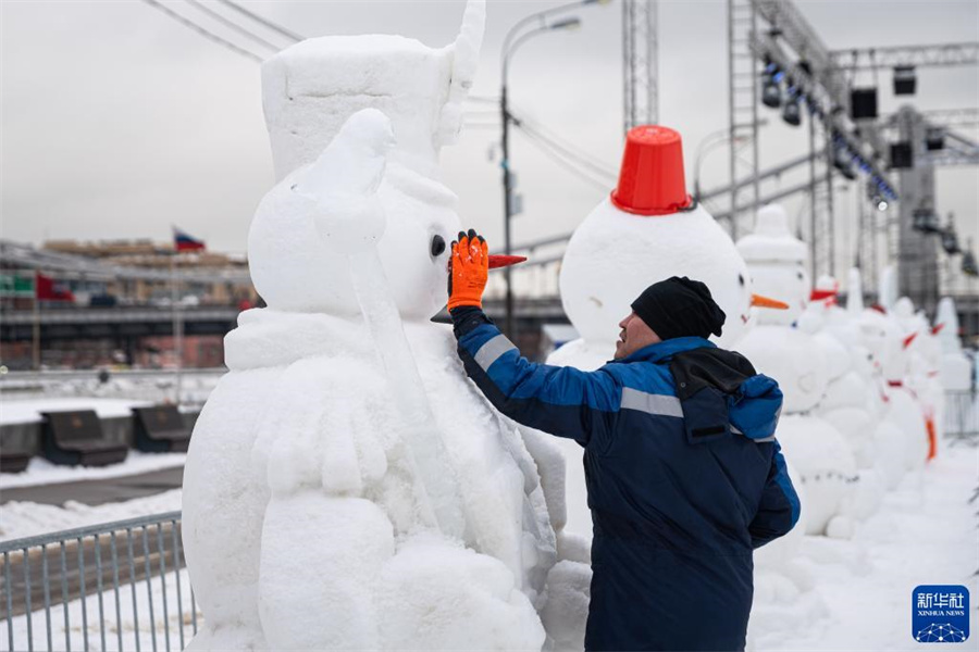2月10日，在俄罗斯莫斯科高尔基公园，工作人员修补展出的雪人。新华社记者 白雪骐 摄