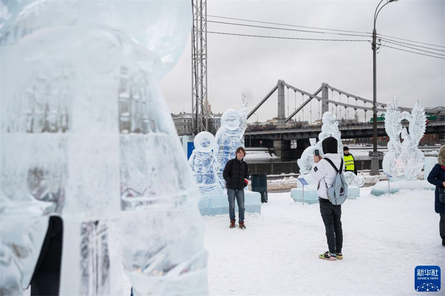 2月10日，在俄罗斯莫斯科高尔基公园，游客在冰雕前拍照。新华社记者 白雪骐 摄