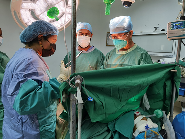 图为段云飞医生（站立者右一）率国际团队进行手术的情景。圭亚那乔治敦公立医院医生 拉姆茹（Ramjoo）摄