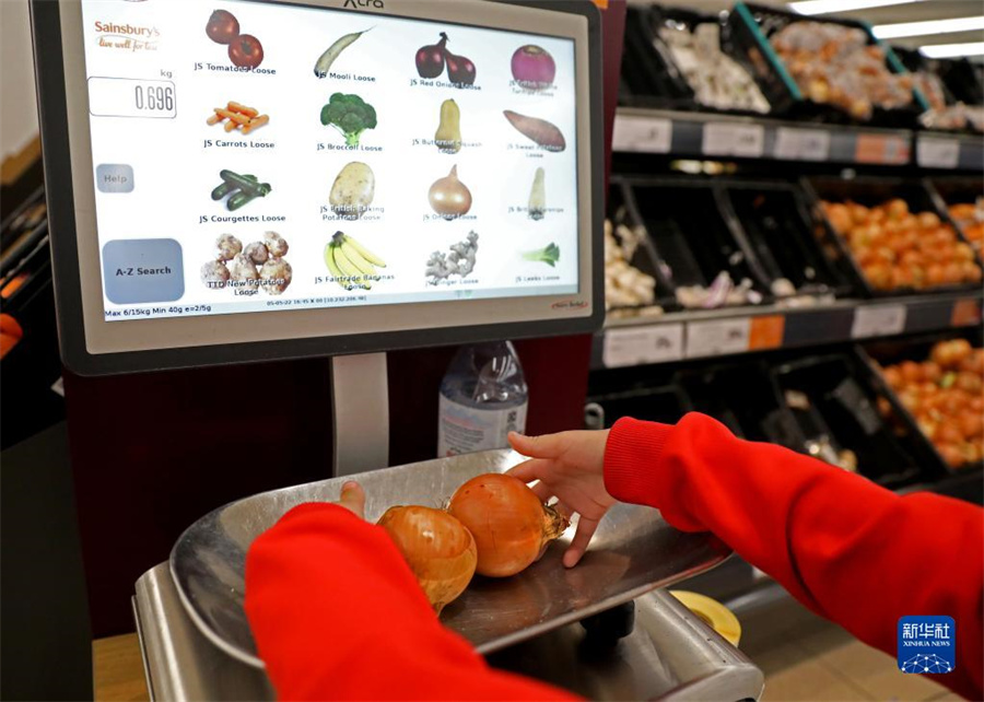 5月5日，在英国伦敦一家超市，一名顾客为食物称重。新华社记者李颖摄