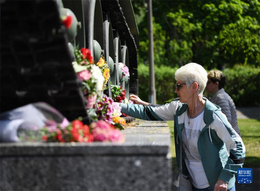 5月8日，在德国首都柏林的德俄博物馆，一名女子在一辆用于展览的坦克旁献花。当日是第二次世界大战“欧洲胜利日”，人们自发来到位于德国柏林东南部的德俄博物馆，纪念战胜德国法西斯77周年。新华社记者 任鹏飞 摄