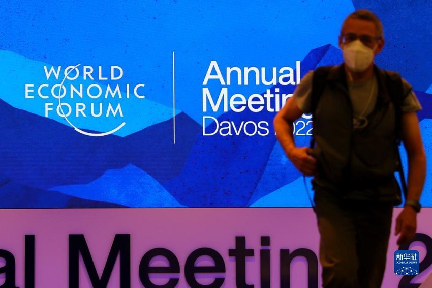 5月21日，在瑞士达沃斯，一名男子经过世界经济论坛2022年年会标识。