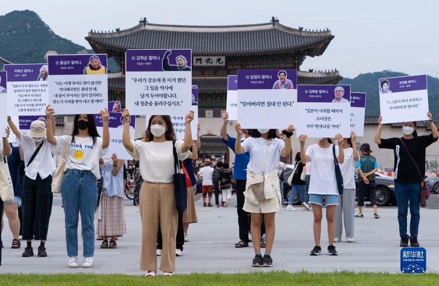 8月14日，在韩国首尔，民众举着日军“慰安妇”受害者照片和证言在光化门广场举行抗议集会。