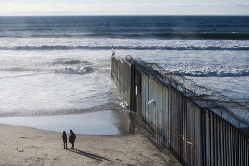 2019年1月10日，在墨西哥边境城市蒂华纳，游客在美墨边境墙边交谈。新华社记者 辛悦卫摄