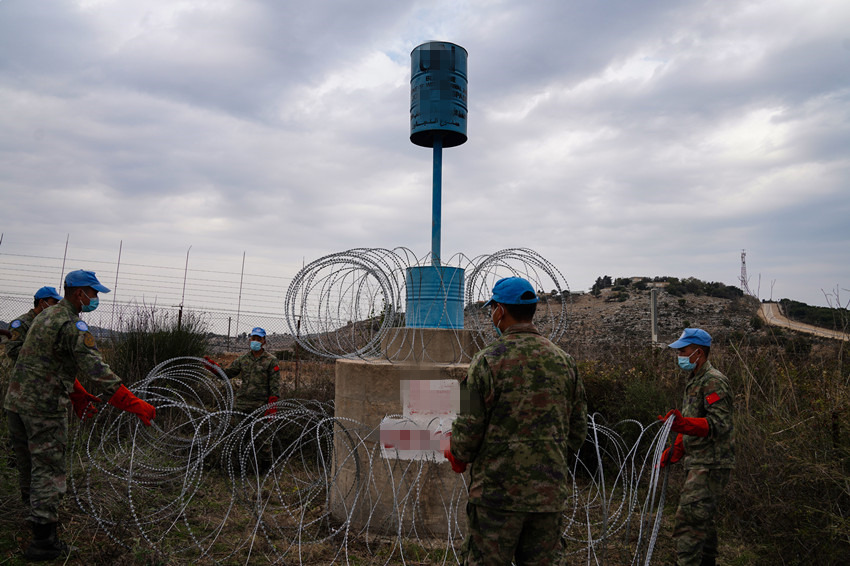 贝鲁特当地时间11月24日，黎巴嫩南部边境“蓝线”附近，中国第21批赴黎巴嫩维和部队部队扫雷官兵开始执行“蓝桶”维护任务，图为官兵正在“蓝桶”上加装铁丝网。李竹林摄