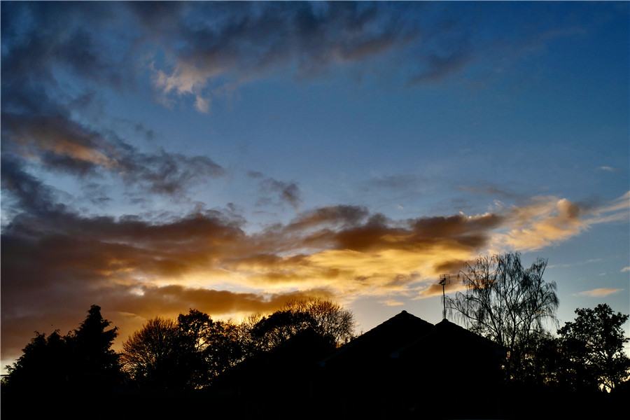 英国牛津郡日落时分 天空透过云层泛着金色