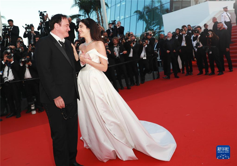 5月27日，在法国戛纳国际电影节上，美国导演昆汀・塔伦蒂诺（左）踏上闭幕式红毯。新华社记者 高静 摄