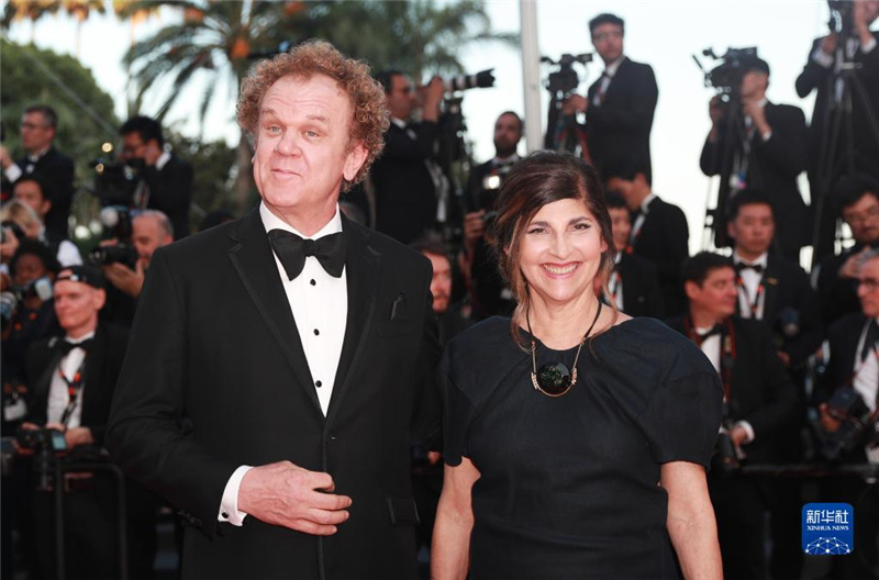 5月27日，在法国戛纳国际电影节上，“一种关注”单元评委会主席、美国演员约翰・克里斯托弗・赖利（左）踏上闭幕式红毯。新华社记者 高静 摄