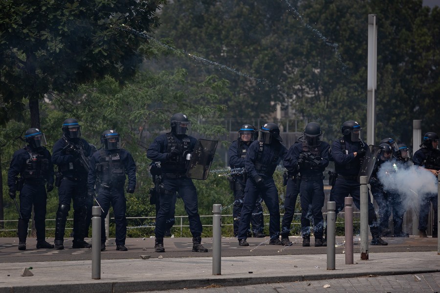 6月29日，在法国上塞纳省楠泰尔市，警察在骚乱现场警戒。新华社发（奥雷利安·莫里萨尔摄）