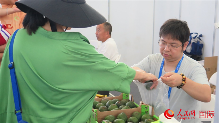 市民在中非经贸博览会现场购买肯尼亚牛油果。人民网 宋歌摄