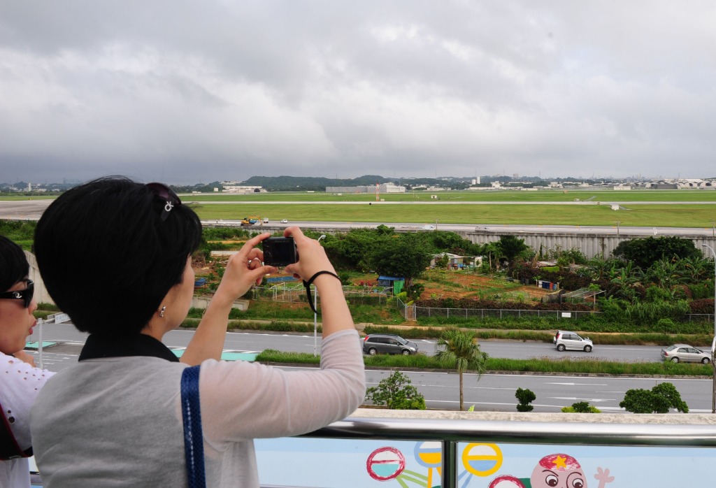 2010年5月18日，一名女子在日本冲绳县嘉手纳町远观美空军驻冲绳嘉手纳基地。新华社记者季春鹏摄