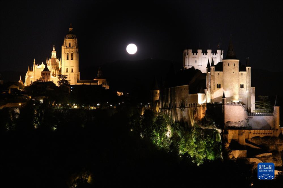 这是8月1日晚在西班牙塞哥维亚拍摄的“超级月亮”和塞哥维亚主教座堂（左）及塞哥维亚城堡。新华社记者 孟鼎博 摄