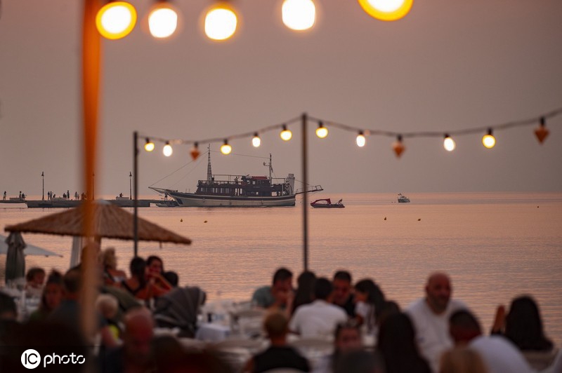 希腊：民众享受海滩日落美景