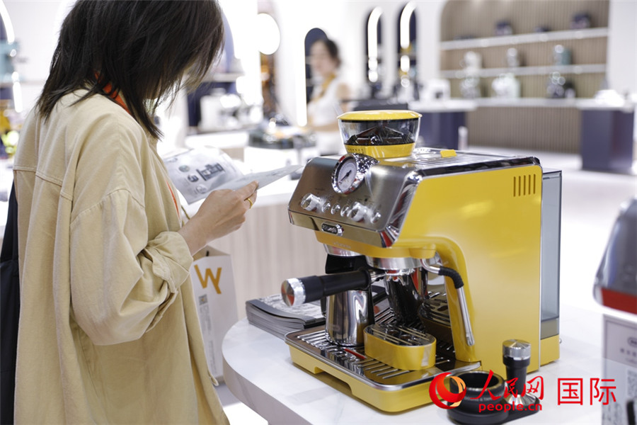 11月5日，一名参观者在消费品展区了解咖啡机功能。人民网记者 李美玉摄