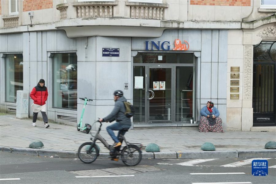 11月15日，人们从比利时布鲁塞尔一家银行网点前经过。新华社记者 赵丁喆 摄