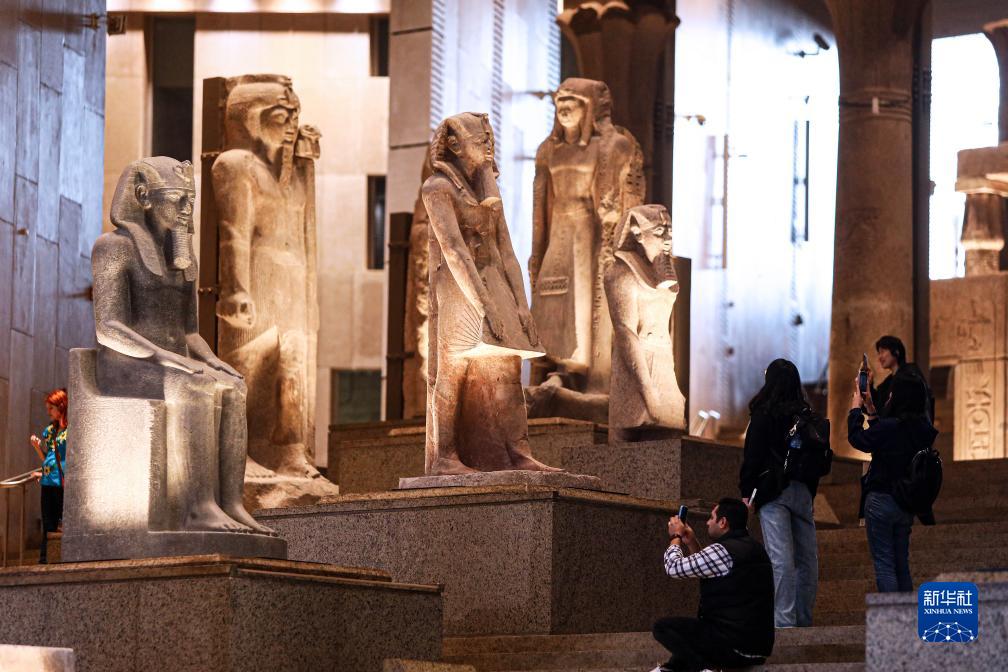 11月30日，人们在埃及吉萨的大埃及博物馆参观“大楼梯”走廊上的雕像。新华社发（艾哈迈德・戈马摄）