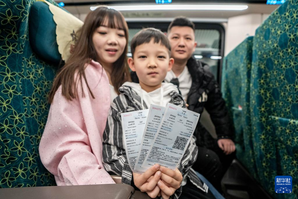 2月14日，在云南昆明，乘坐中老铁路国际旅客列车前往老挝的游客展示购买到的车票。新华社记者 胡超 摄